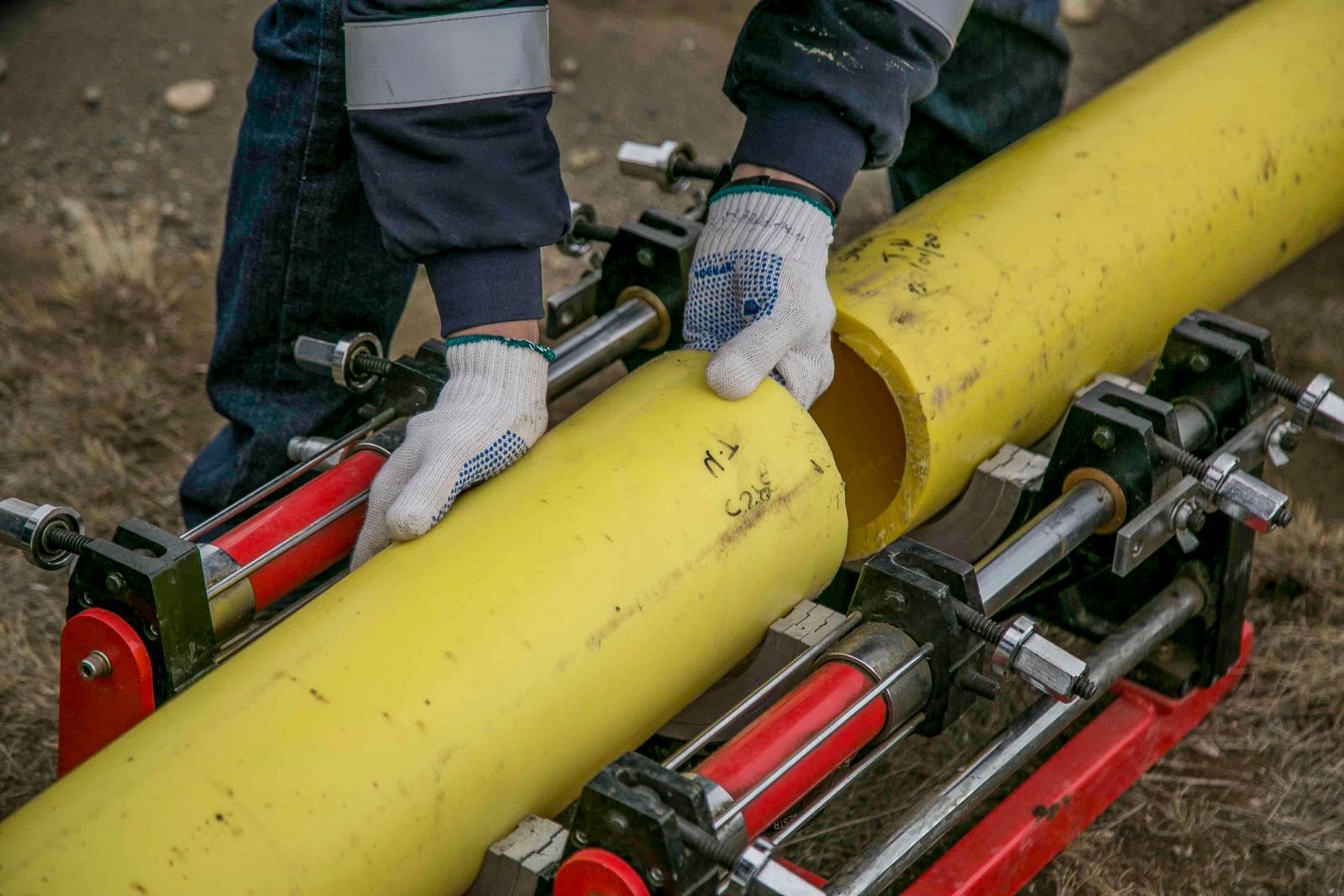 Technician joining yellow gas distribution pipes