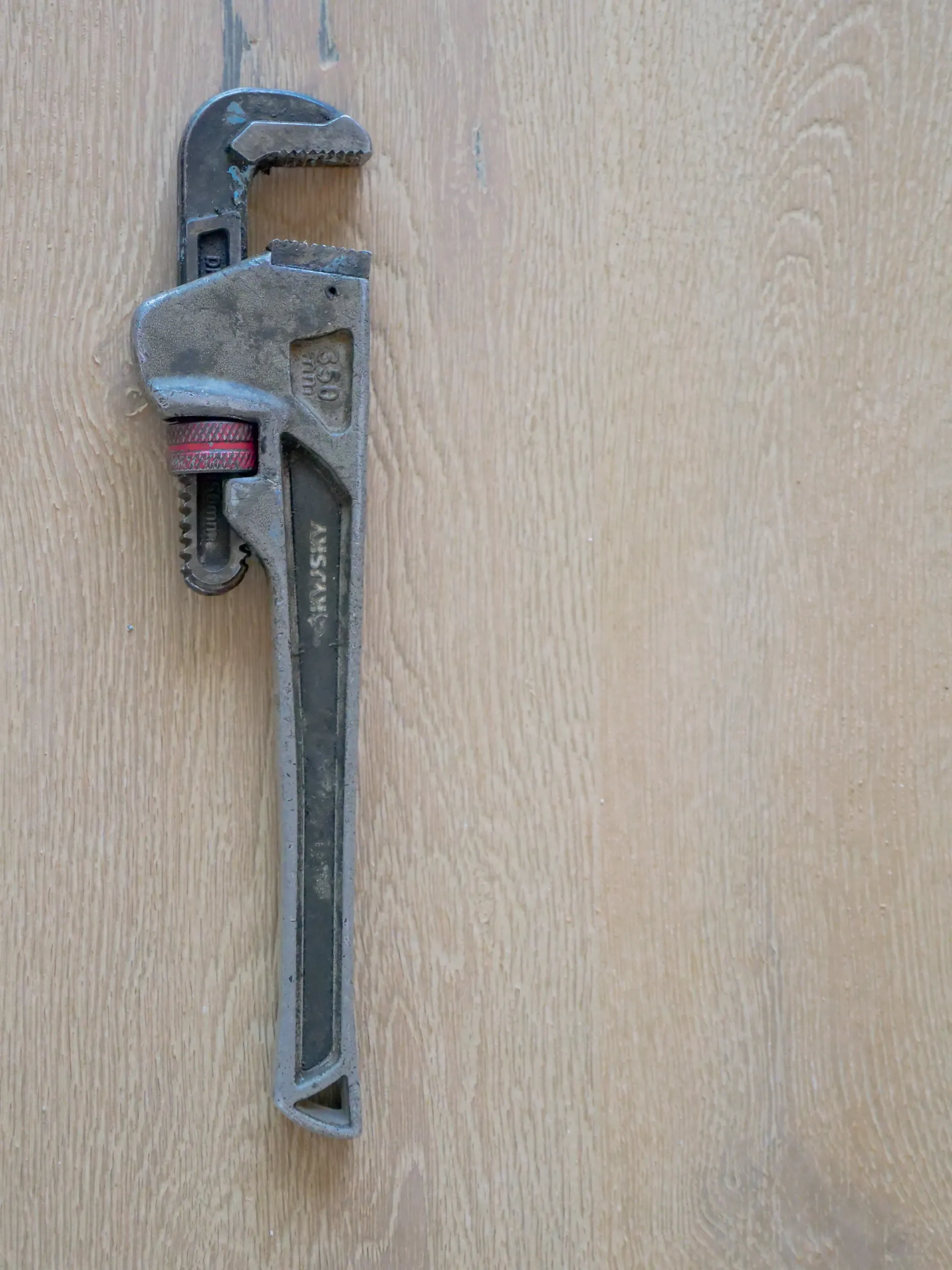 Close-up of a plumber's wrench on a pipe fitting
