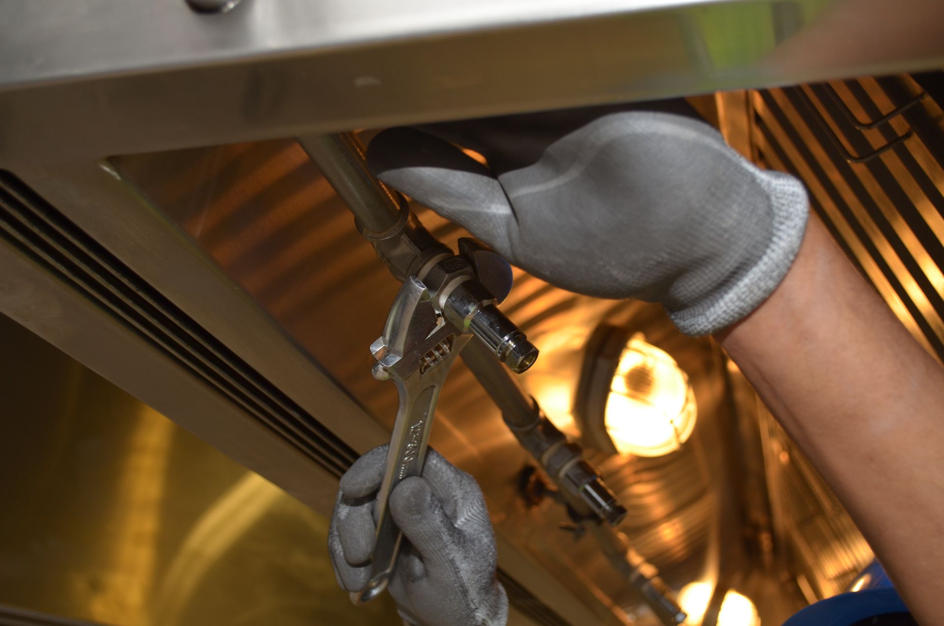 Plumber tightening a fitting with a wrench during an emergency repair