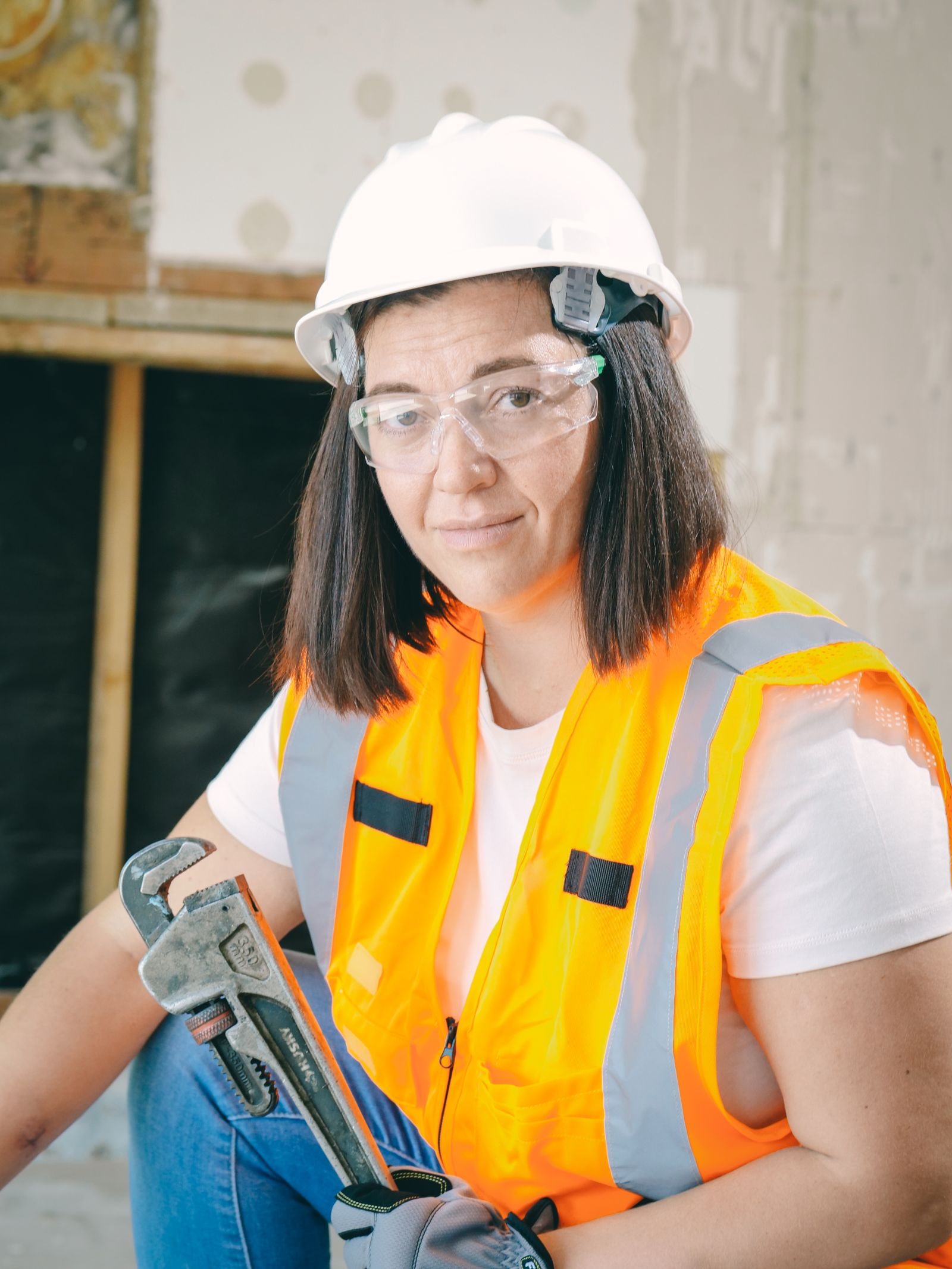 Professional plumber in uniform holding a wrench
