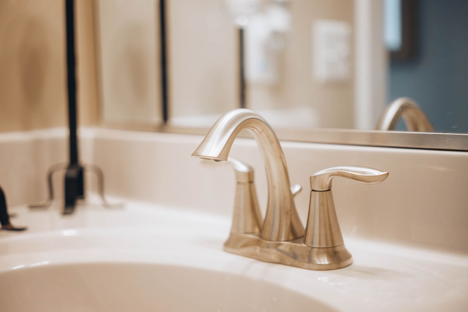 Modern stainless-steel faucet mounted on a white ceramic sink
