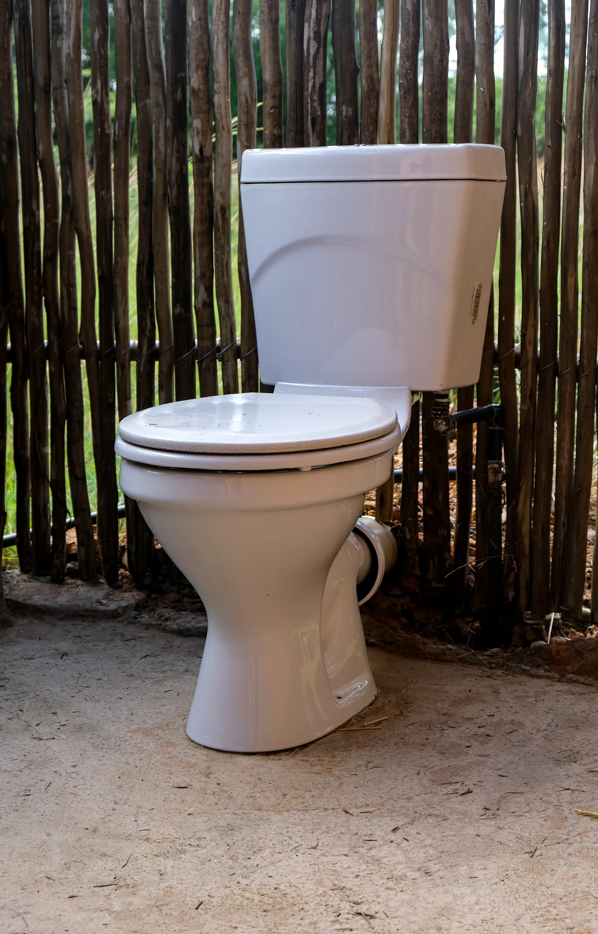 White ceramic toilet bowl installed in a tiled bathroom